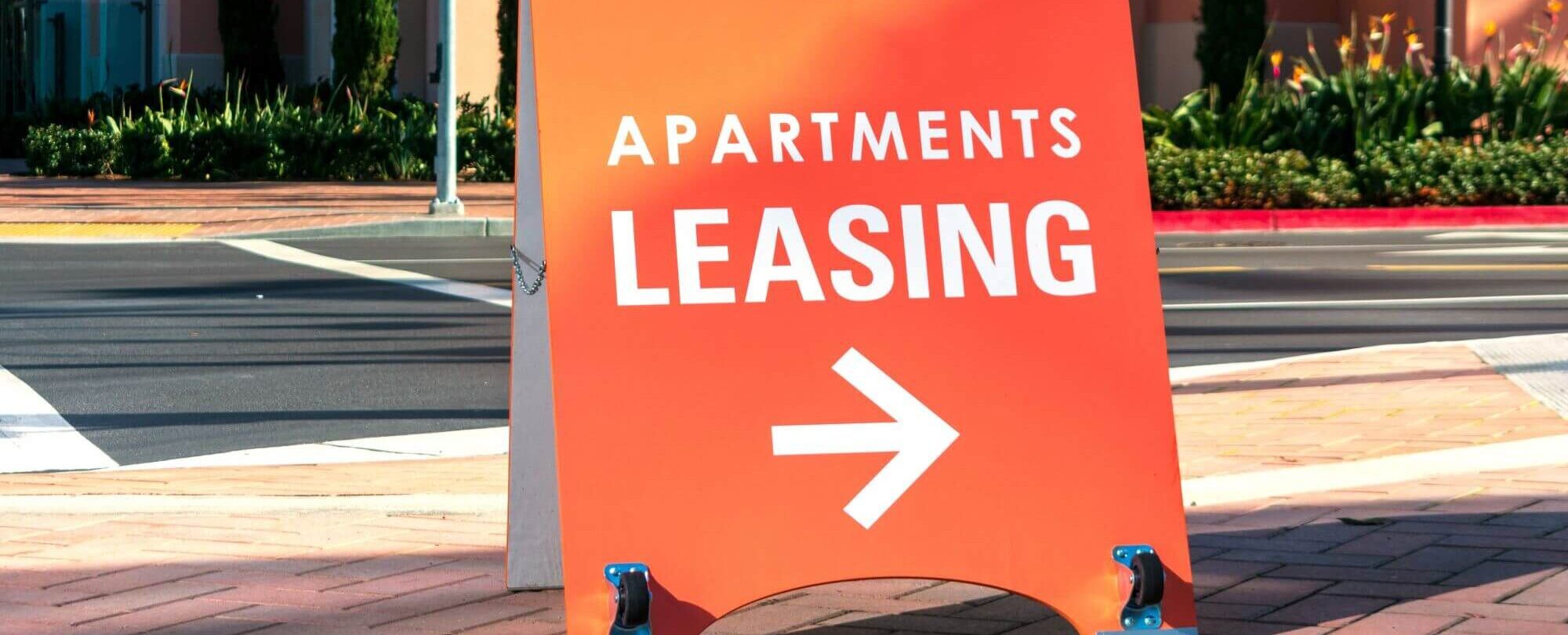 A sign with an arrow pointing at apartments for lease